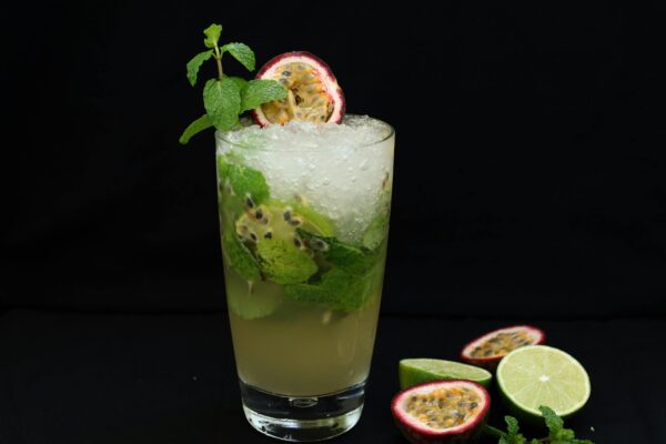 A close-up of a refreshing passion fruit mojito garnished with mint and lime, perfect for a summer day.
