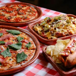 Savory assortment of pizza and cheesy nachos served on a rustic table in San Cristóbal de las Casas.