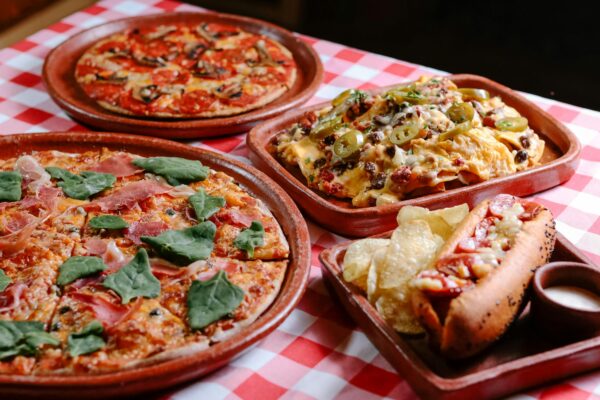 Savory assortment of pizza and cheesy nachos served on a rustic table in San Cristóbal de las Casas.