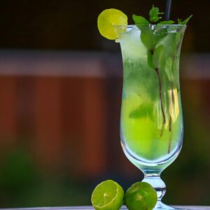 A vibrant mojito cocktail served with lime and mint leaves in a tall glass.