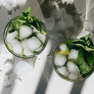 Overhead shot of mojito cocktails with ice and mint leaves, perfect for a cool refreshment.