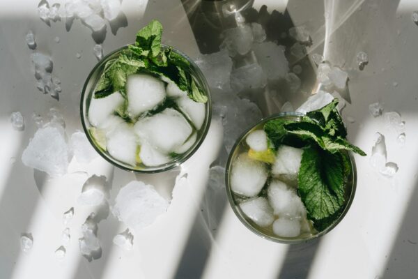 Overhead shot of mojito cocktails with ice and mint leaves, perfect for a cool refreshment.