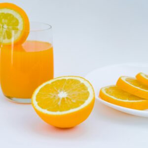 Vibrant orange juice with lemon and orange slices, perfect for a healthy lifestyle.