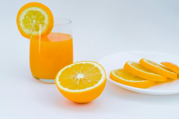Vibrant orange juice with lemon and orange slices, perfect for a healthy lifestyle.