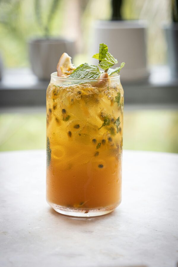 Delicious tropical mojito with mint and citrus garnish served in a transparent glass.