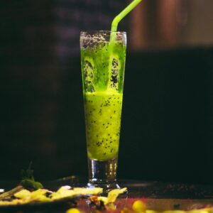 Inviting kiwi smoothie with straw in a tall glass. Perfect refreshment.