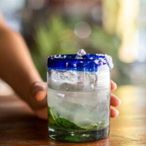 Close-up of a refreshing iced cocktail with mint leaves on a wooden table.
