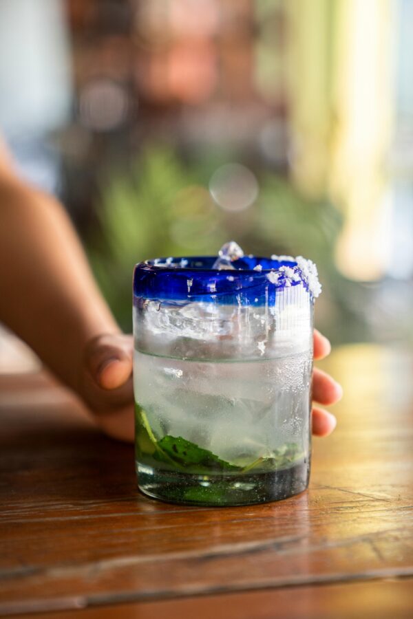 Close-up of a refreshing iced cocktail with mint leaves on a wooden table.