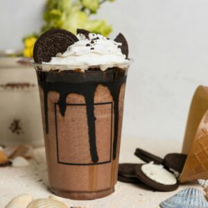 A mouthwatering chocolate milkshake topped with whipped cream and Oreo cookies, perfect for sweet cravings.