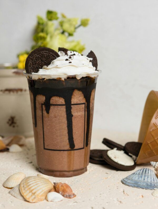 A mouthwatering chocolate milkshake topped with whipped cream and Oreo cookies, perfect for sweet cravings.